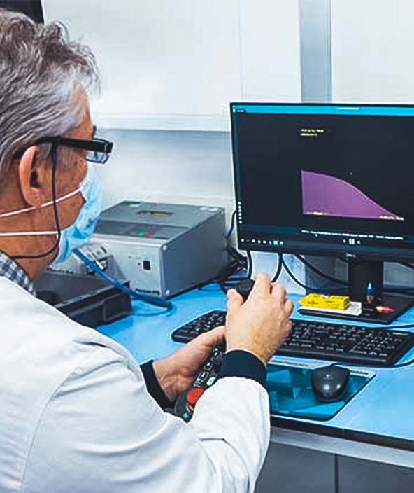 Un tecnico L'Oréal seduto al computer utilizza misure di precisione durante la produzione
