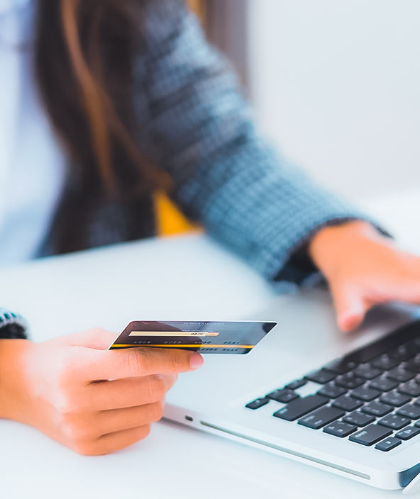 Retrato de uma mulher utilizando um cartão de crédito com laptop para fazer compras online