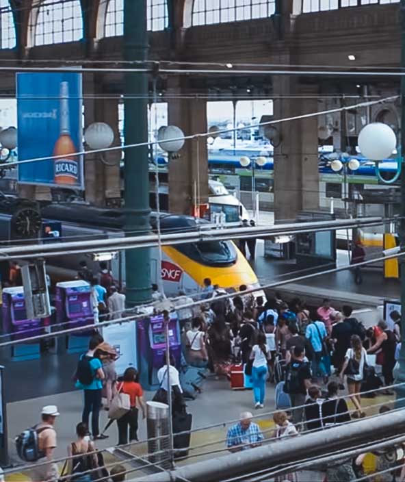 Passengers in a busy station wait for the next available train
