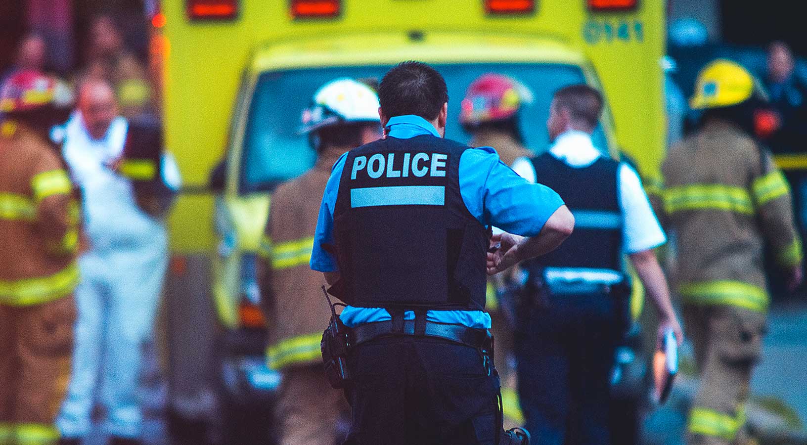 Image d’agents de police et de pompiers devant un véhicule d’intervention.