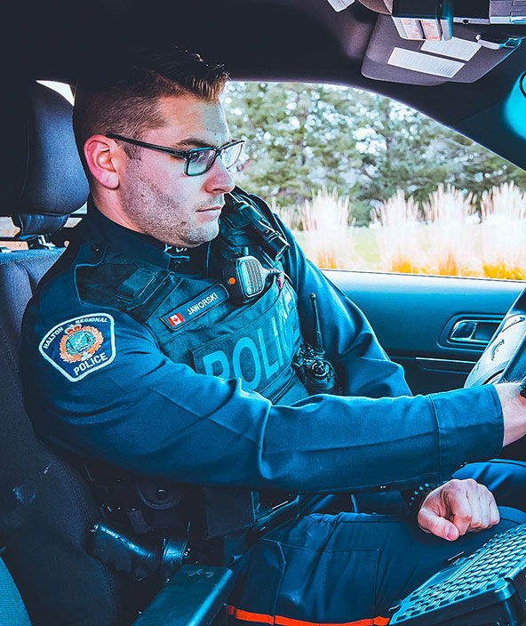 a police officer using their laptop in their car