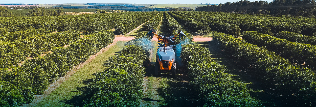 An autonomous tractor in a field spraying crops