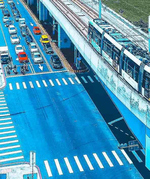 Aerial view of metro trains passing each other on a curve near Xinshi 1st Road Station next to residential towers in a community in Tamsui District, New Taipei