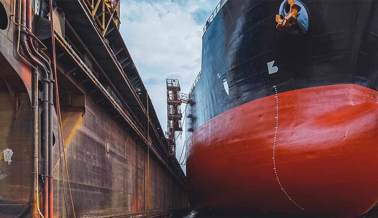 A large tanker ship with renovations underway at a shipyard