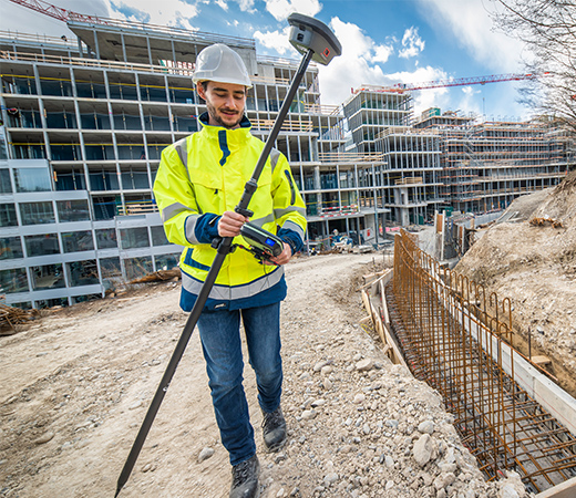 Surveyor on a construction site measures with a GNSS smart antenna