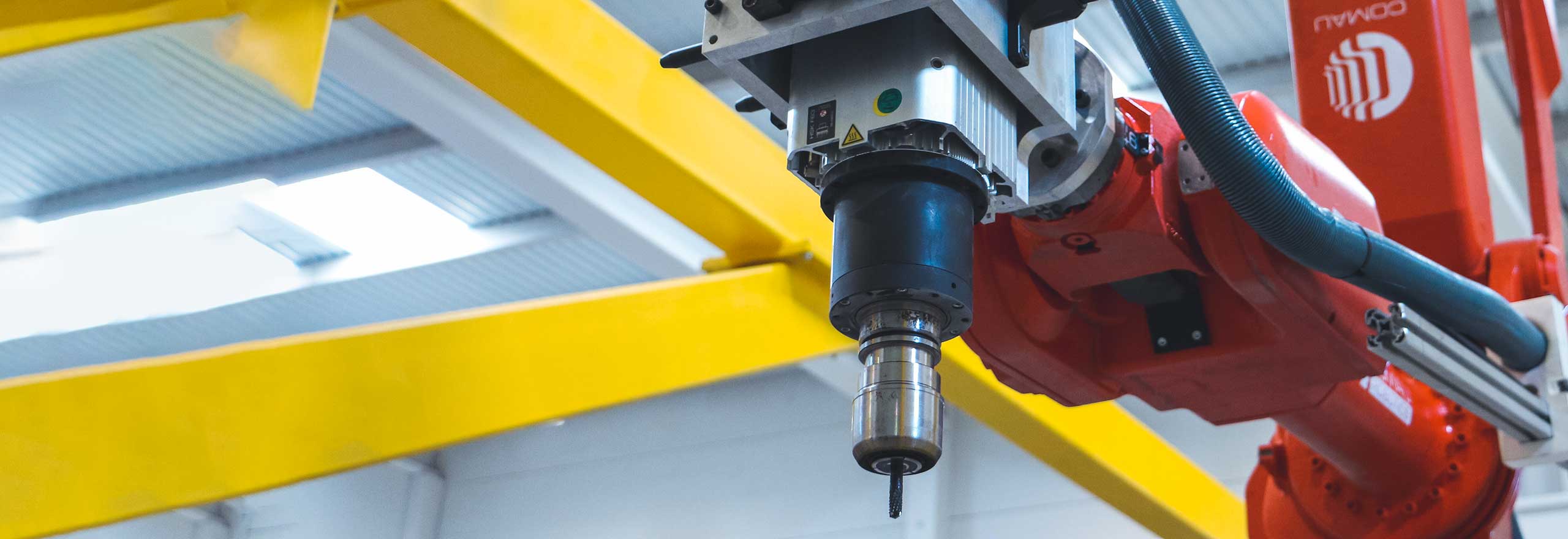 Um sensor de controle de máquina montado em um robô industrial garante operações de perfuração precisas.