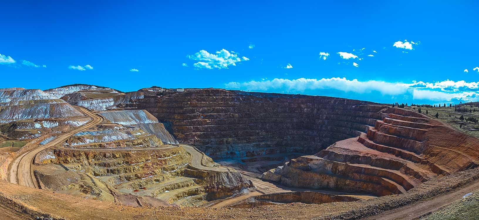 wide view of open pit mine under blue skies