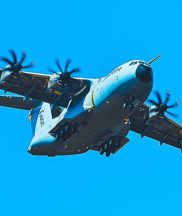 Military aircraft in flight above clear blue sky