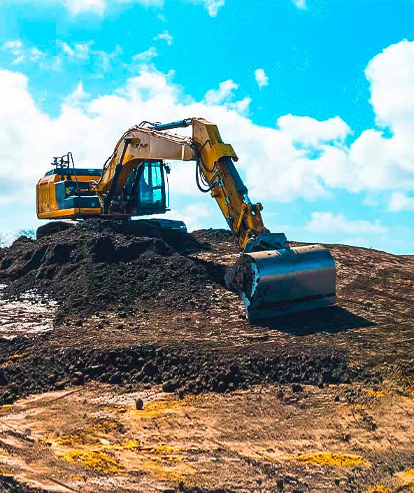 Excavator digging and fine grading on construction site