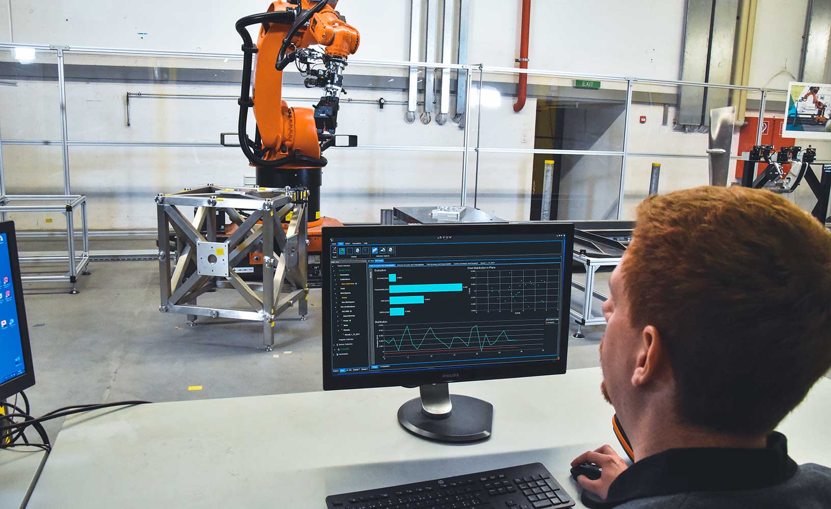 Industrial robot undergoing calibration by operator using software.
