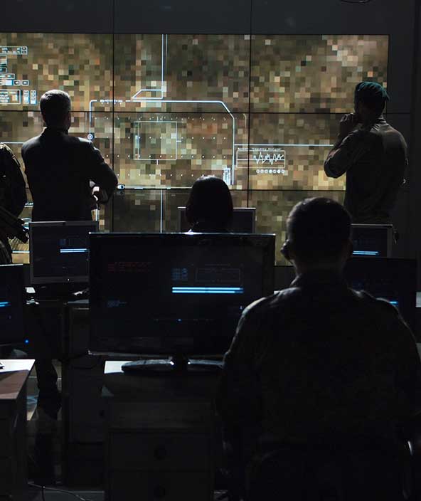  Intelligence specialists gather around a projected image. 