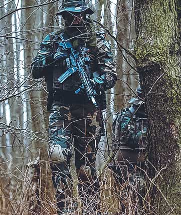 Operatori militari nei pressi di un bosco che svolgono operazioni di guerra.