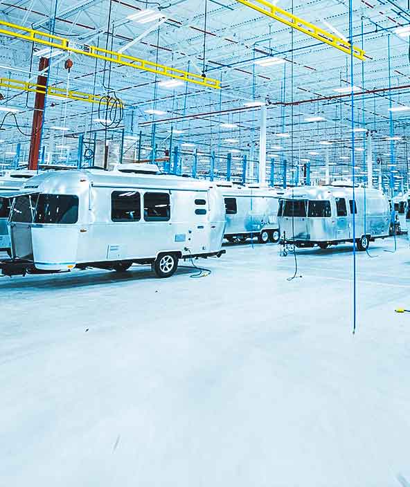 Several Airstream travel coaches in a factory environment  