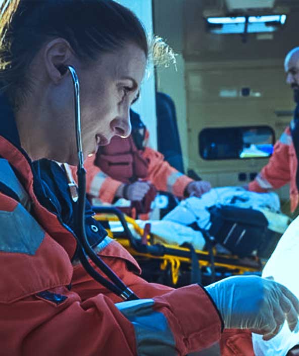 Female EMS worker give oxygen and lifesaving care to an injured person.