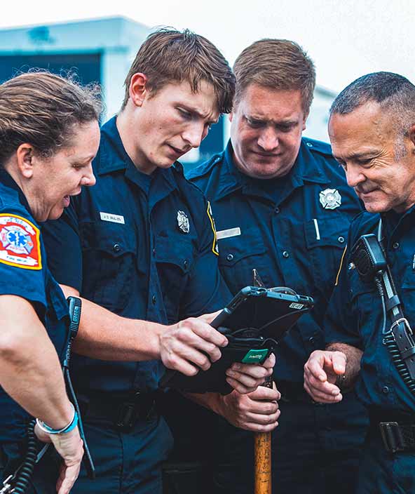 policiais, bombeiros e socorristas analisam informações e detalhes de incidentes em um tablet.