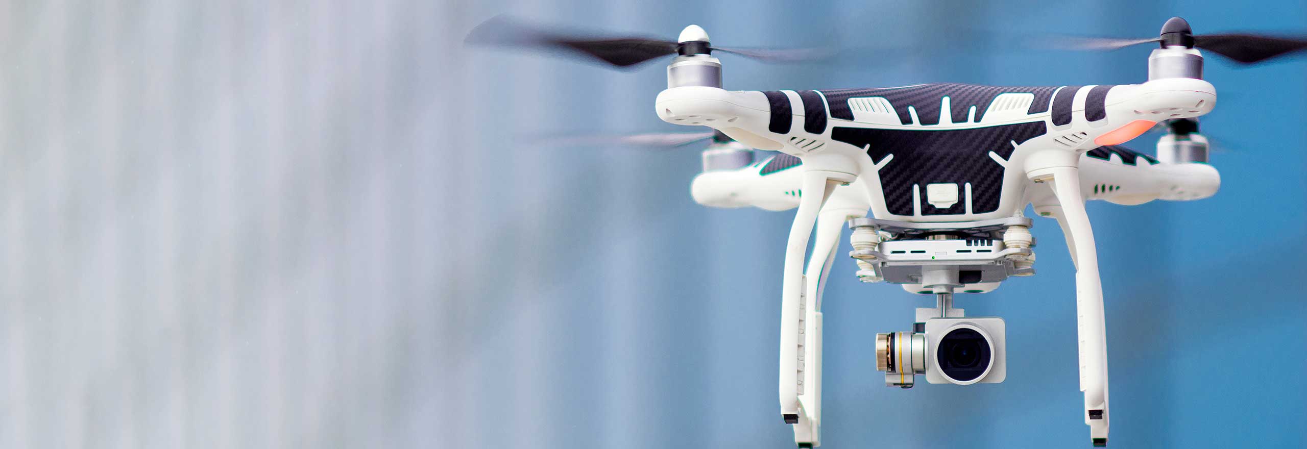 Schwebende Drohne mit Kamera auf blauem Hintergrund