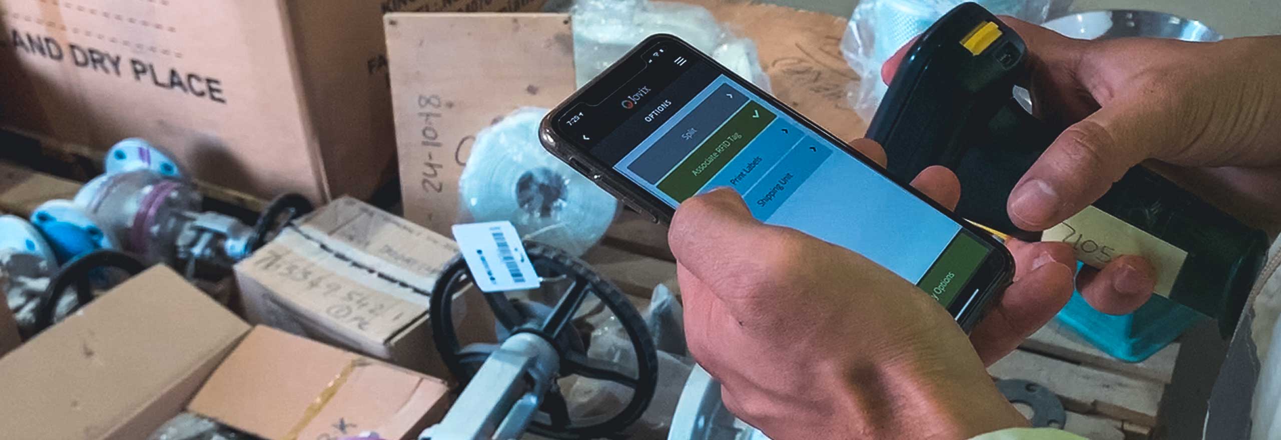 Close up of supply manager with smartphone in front of various packaged products