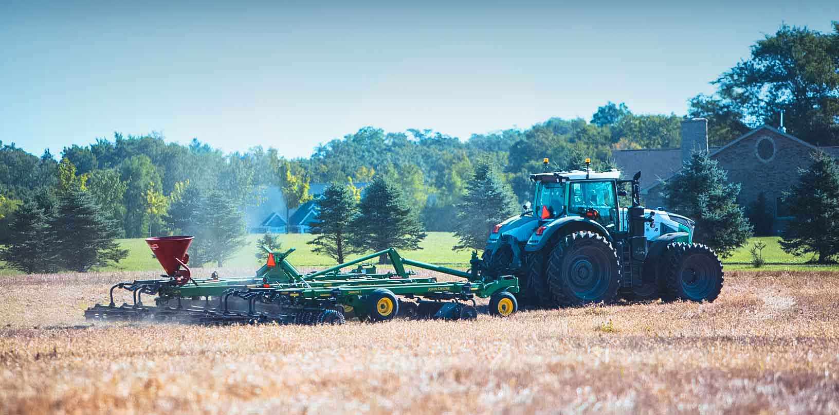 Autonomer Traktor von Hexagon zieht eine Saatmaschine auf einem Feld.