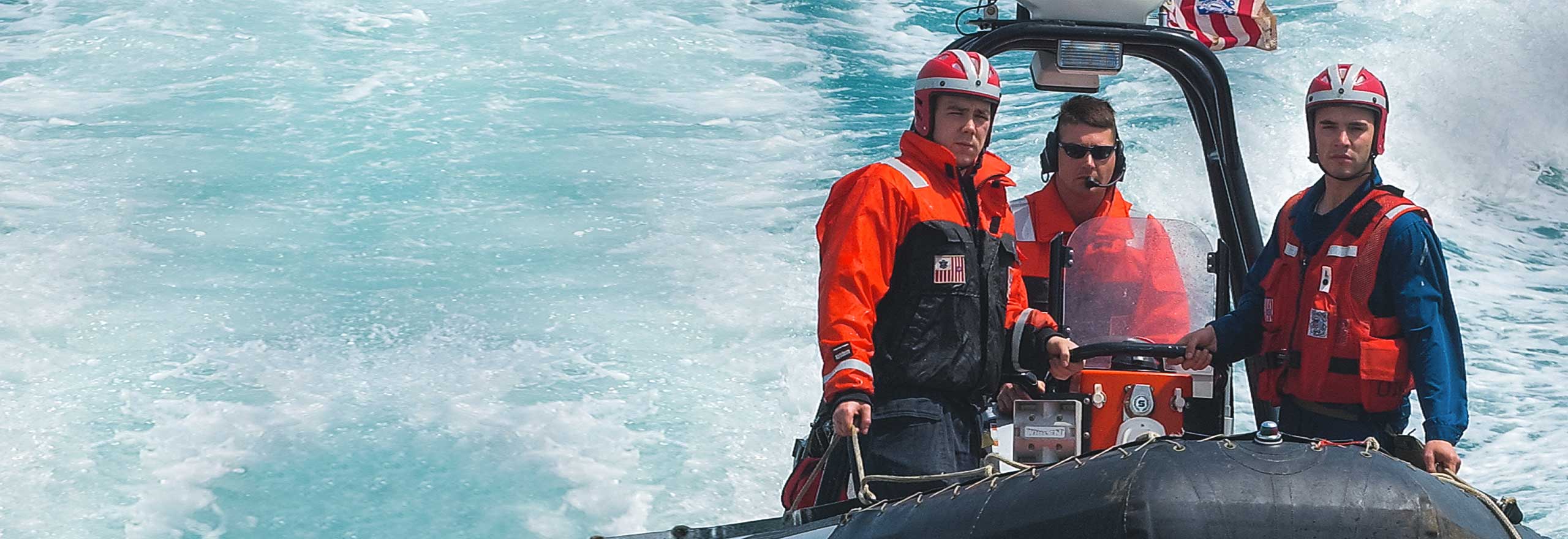 U.S Coast Guard members on boat speeding through open waters