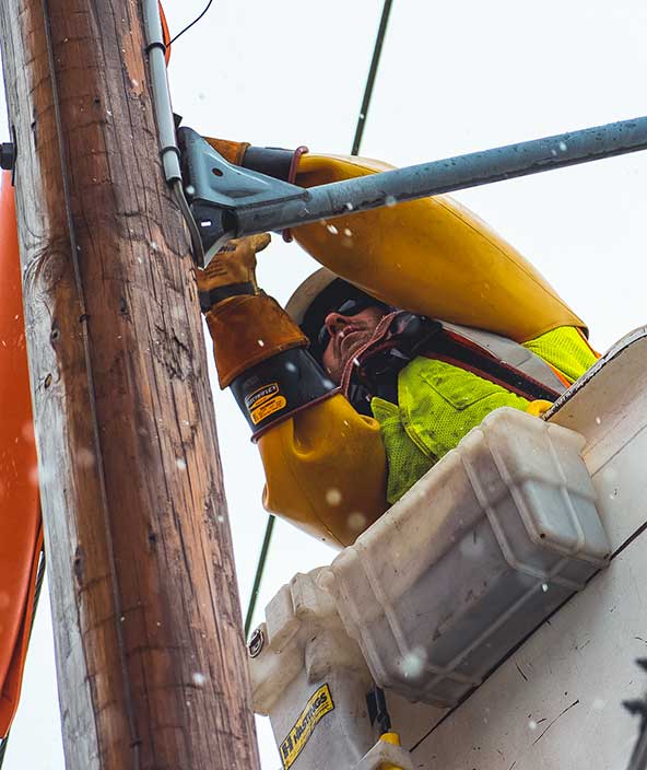 Arbeiter eines Versorgungsunternehmens repariert eine Stromleitung