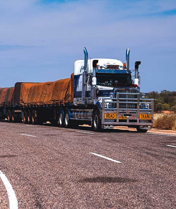Übergroßer/übergewichtiger Truck, der einen Waggon über die Autobahn transportiert.