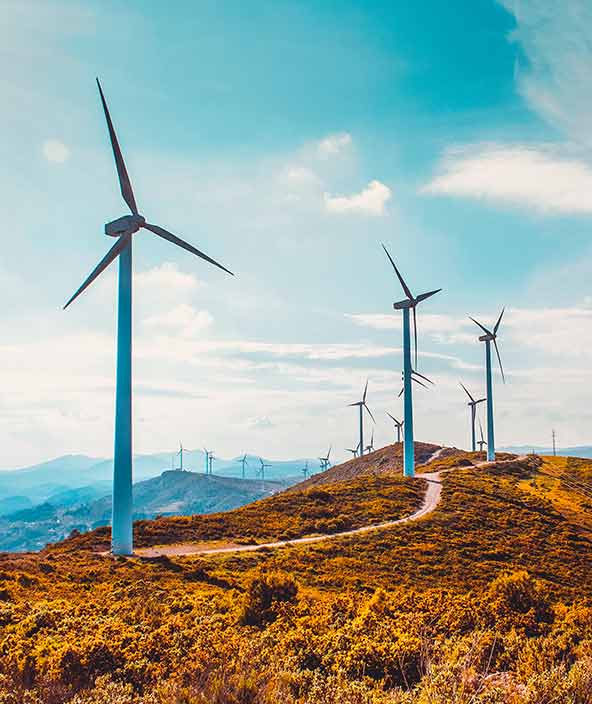 Wind turbines along a curvy road in a mountain landscape 