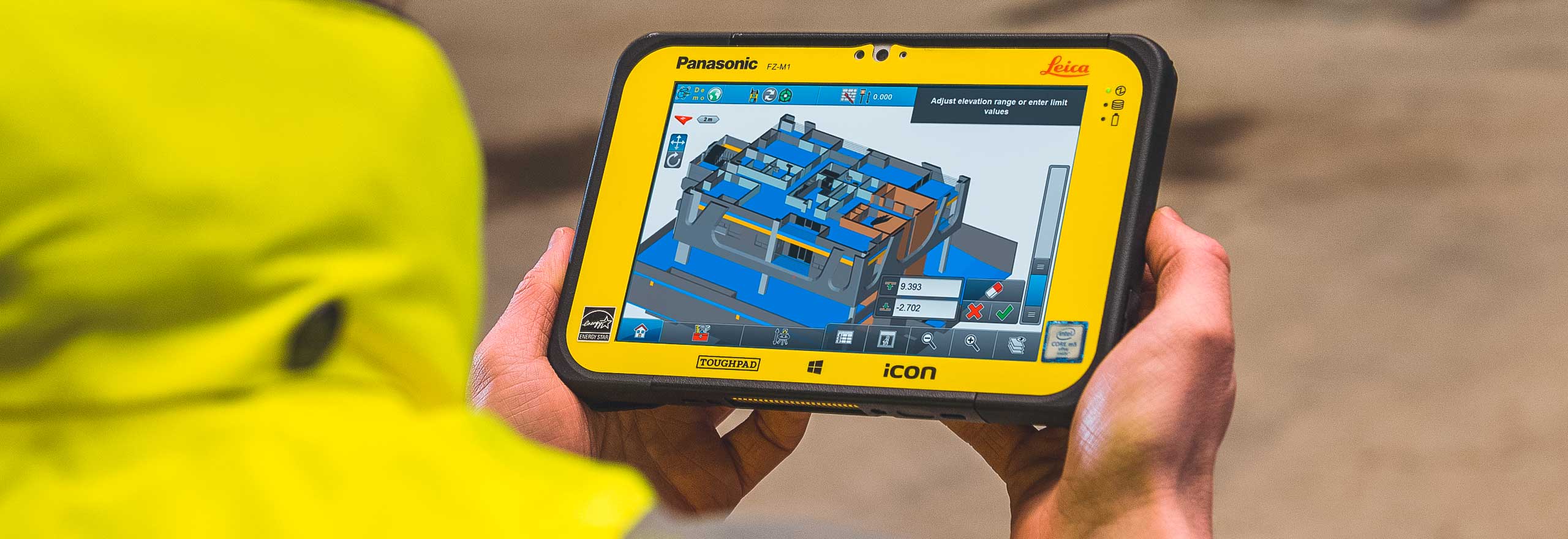 building software displayed on a tablet controller held by a construction worker 