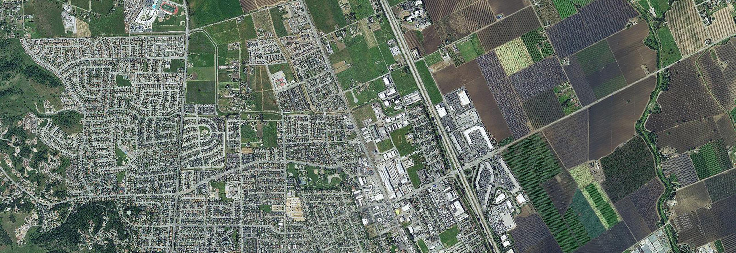 Satellite view of suburban area with agricultural land nearby