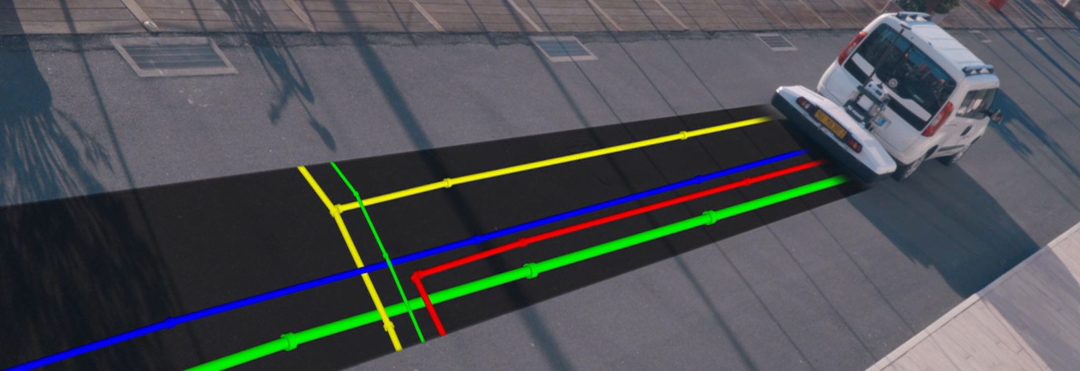 Graphically rendered colored pipes exposed as a van drives past using an attached ground penetrating radar product