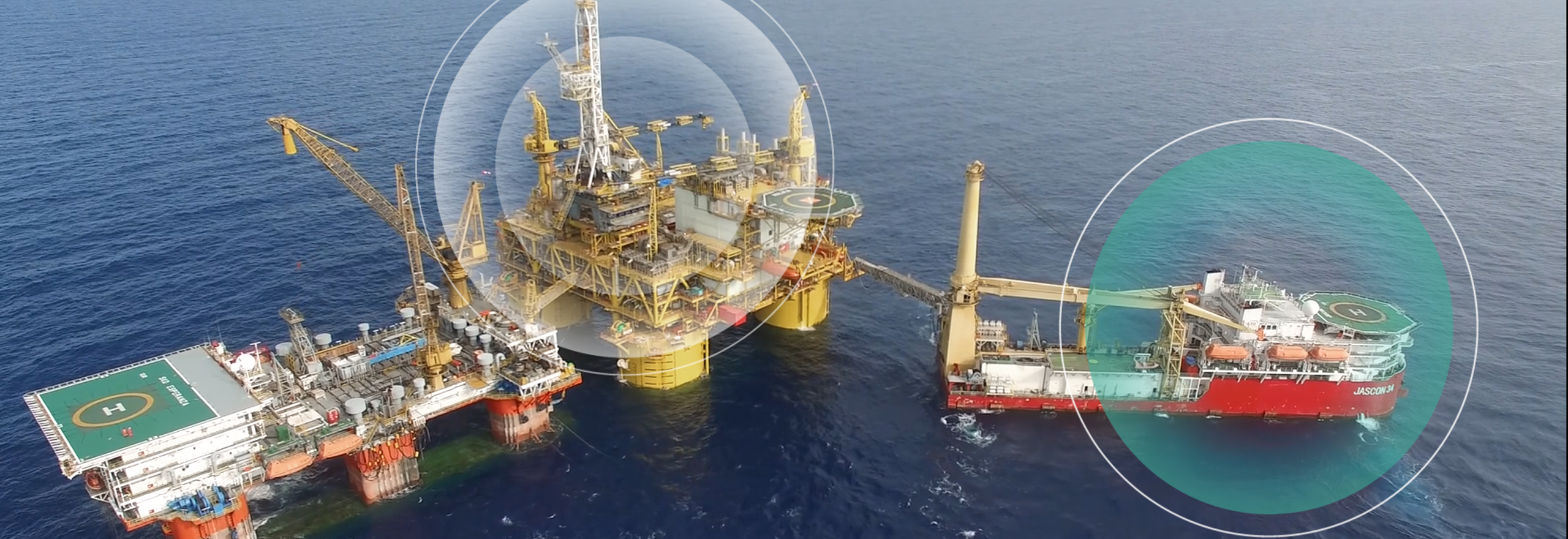A red vessel and offshore oil rig on the ocean with circle overlays. 
