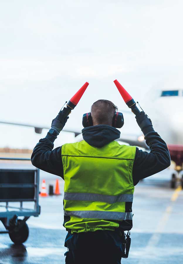 Empleado de aeropuerto ayudando a un avión a prepararse para el despegue