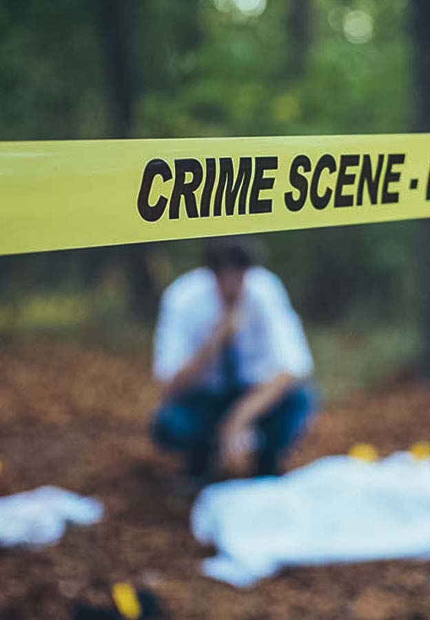 Fita policial amarela ao redor da cena do crime durante a investigação