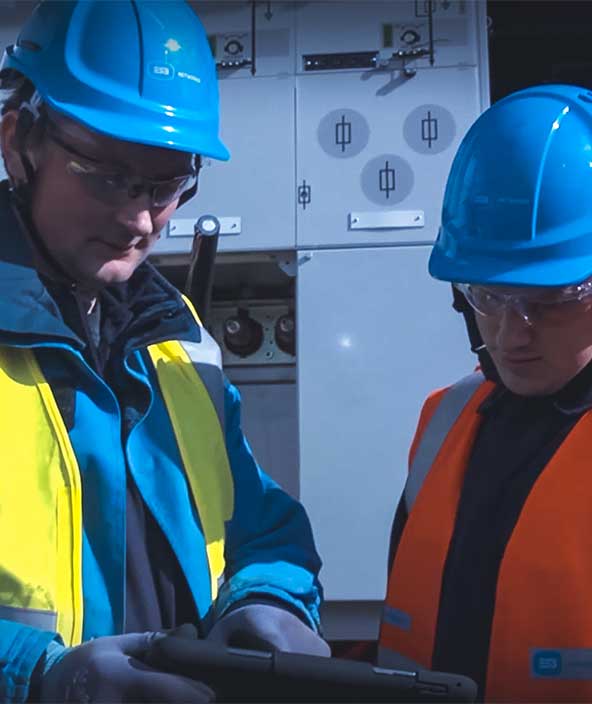 Dos trabajadores de la compañía eléctrica revisan la información en una tableta
