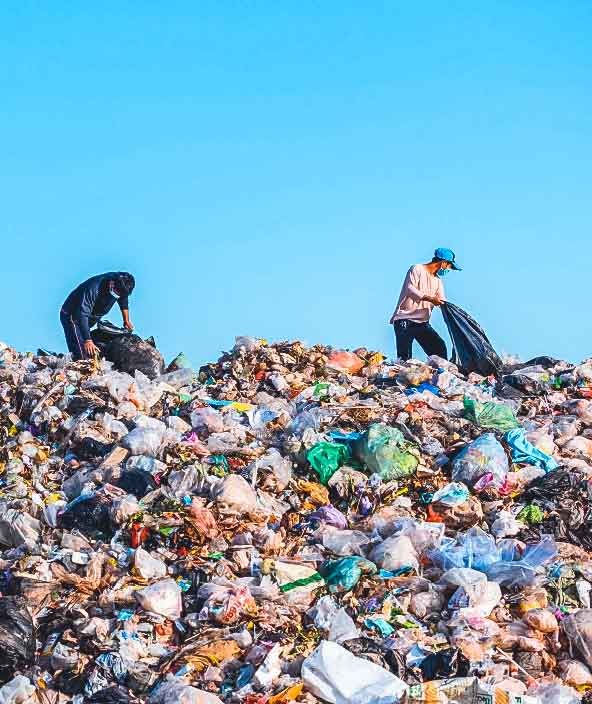 Two men sort through a giant pile of trash