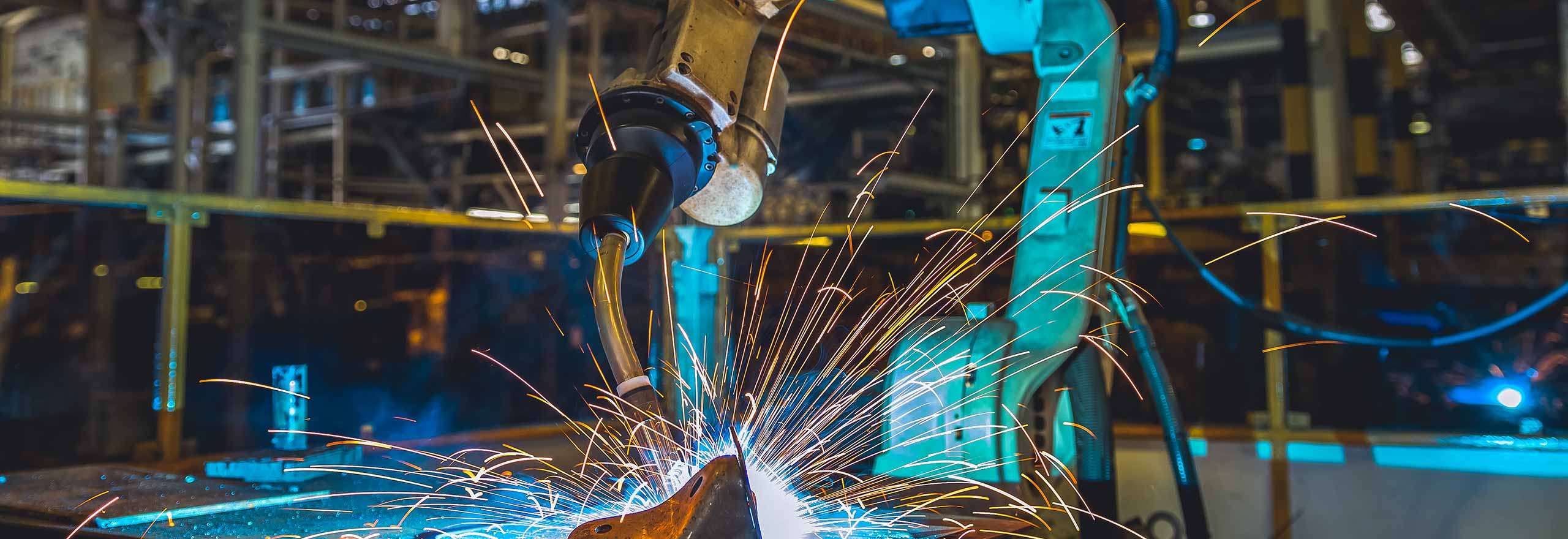 Industrial robot welding a car part in a factory 
