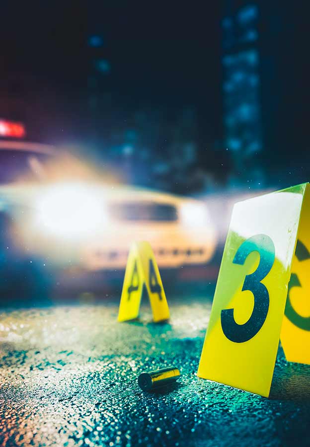 Police car in background of a crime scene with markers