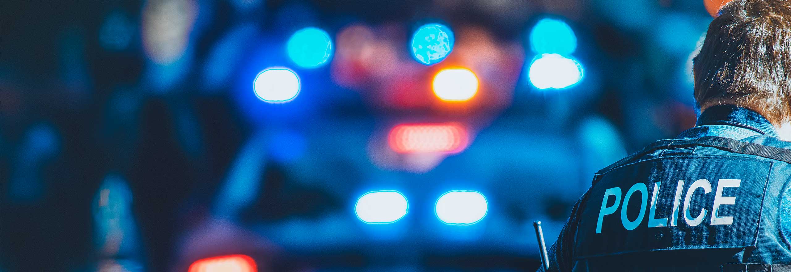 Police car lights glowing blue in nighttime