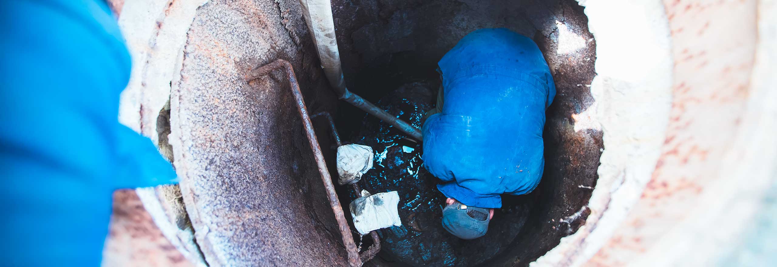 Water utility field technician in a manhole