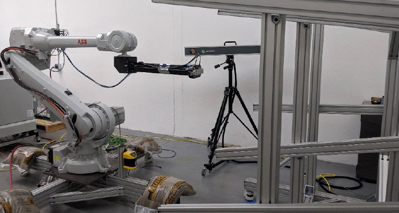 A photogrammetry system and robotic arm inspecting a structure