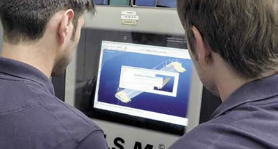 Image of people looking at a computer screen with 3D inspect software displayed on it 