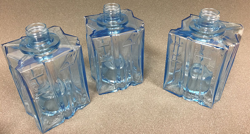 Three clear plastic bottles with a blue tint