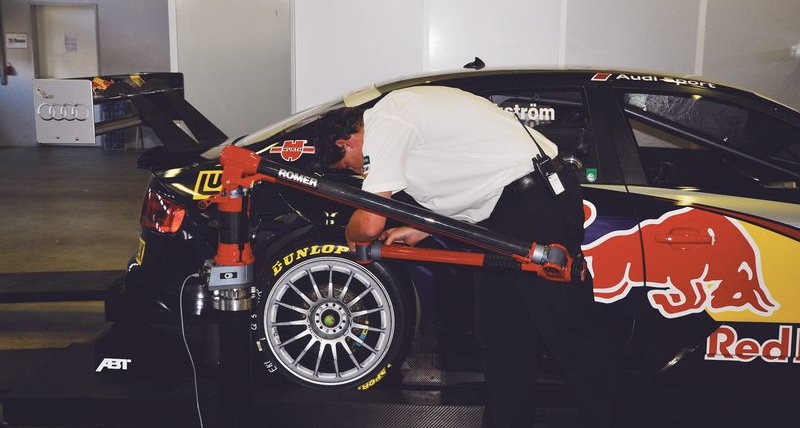 Man using Romer Measuring Arm on racing car in car showroom