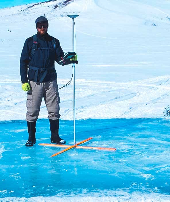 Chercheur debout sur la glace utilisant la technologie Leica d’Hexagon pour étudier le changement climatique