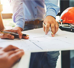 Image of construction professionals pointing at a blueprint 