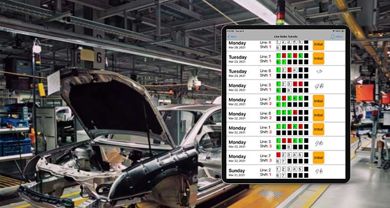 View of a manufacturing worker's smart audit solution on their tablet screen by a car manufacturing line.
