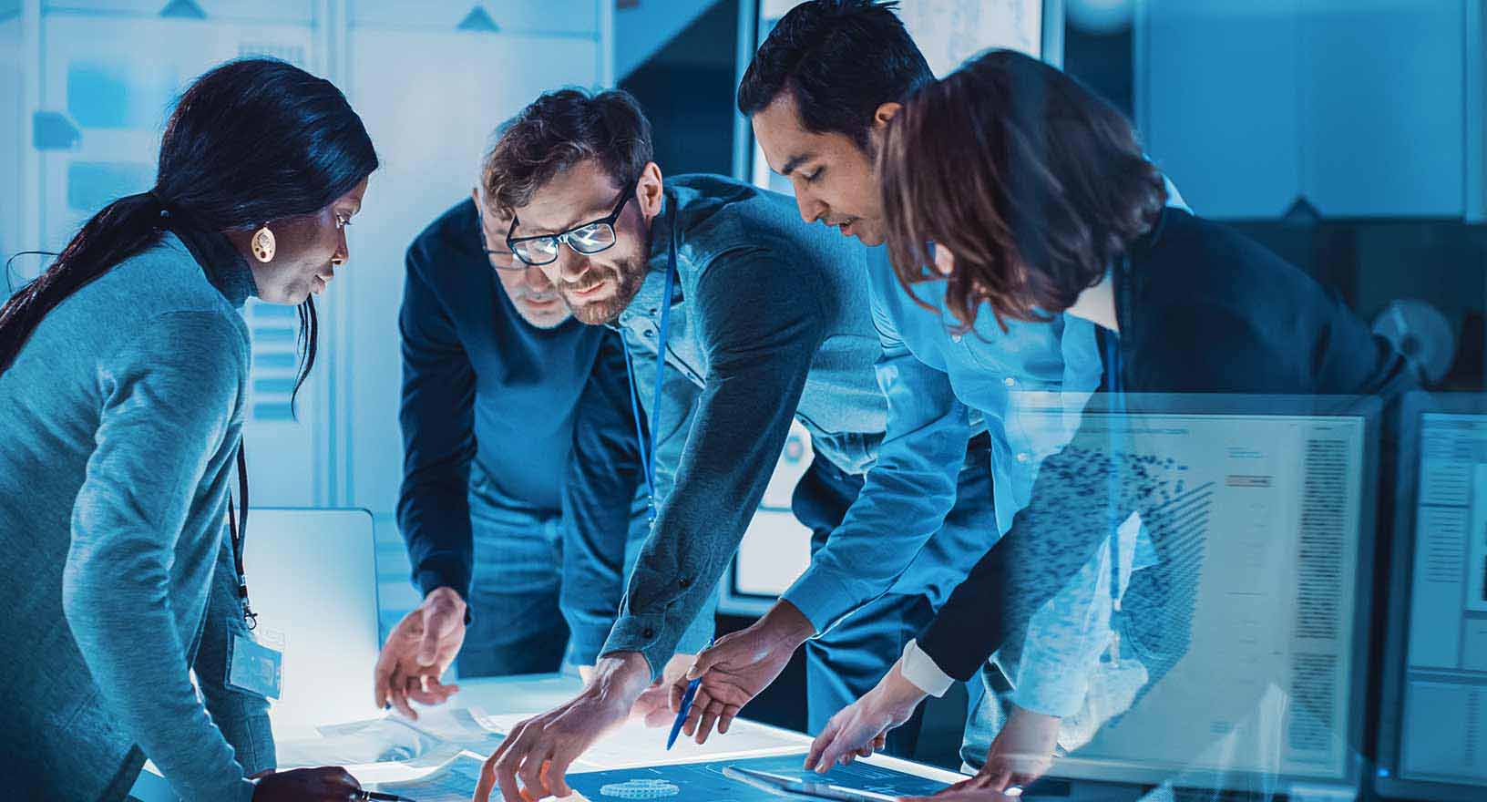 Engineers Meeting in Technology Research Laboratory: Engineers Scientists and Developers Gathered Around Illuminated Conference Table