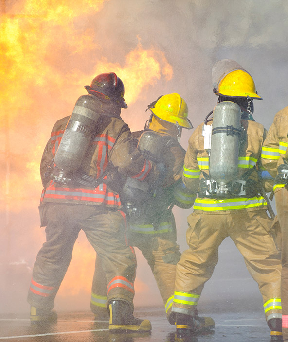 Ein Team von Feuerwehrleuten arbeitet daran, die Flammen zu löschen, die ein brennendes Gebäude zerstören
