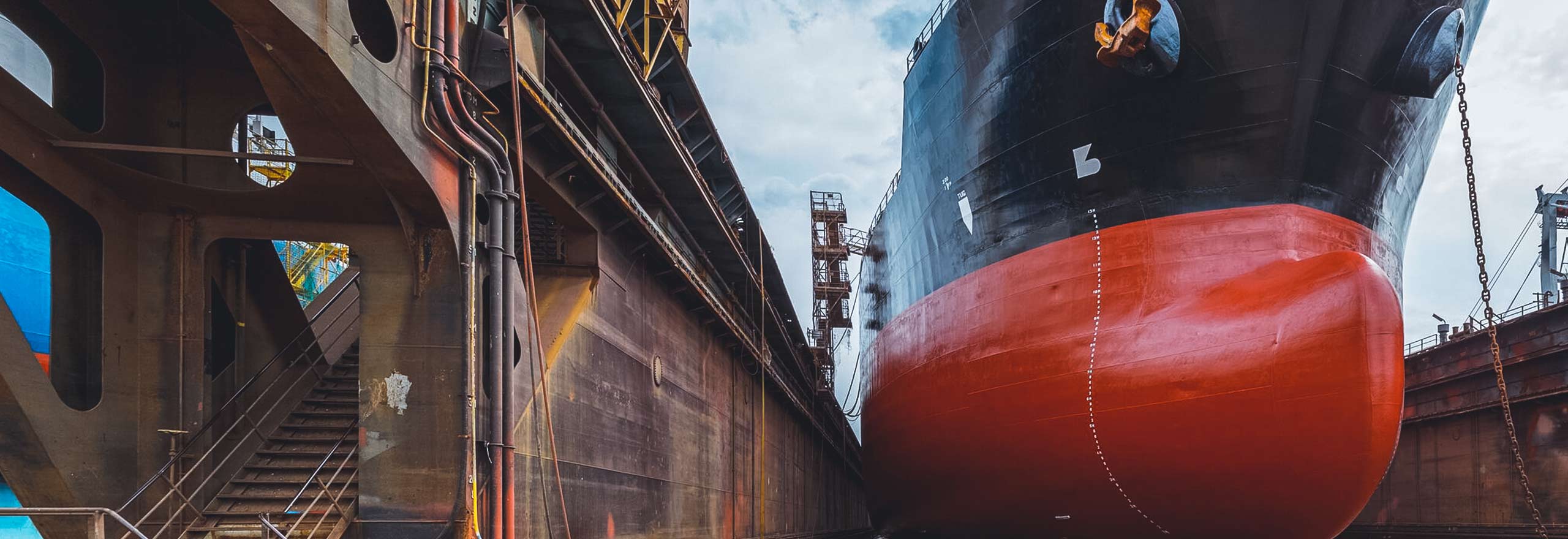 A large tanker ship with renovations underway at a shipyard