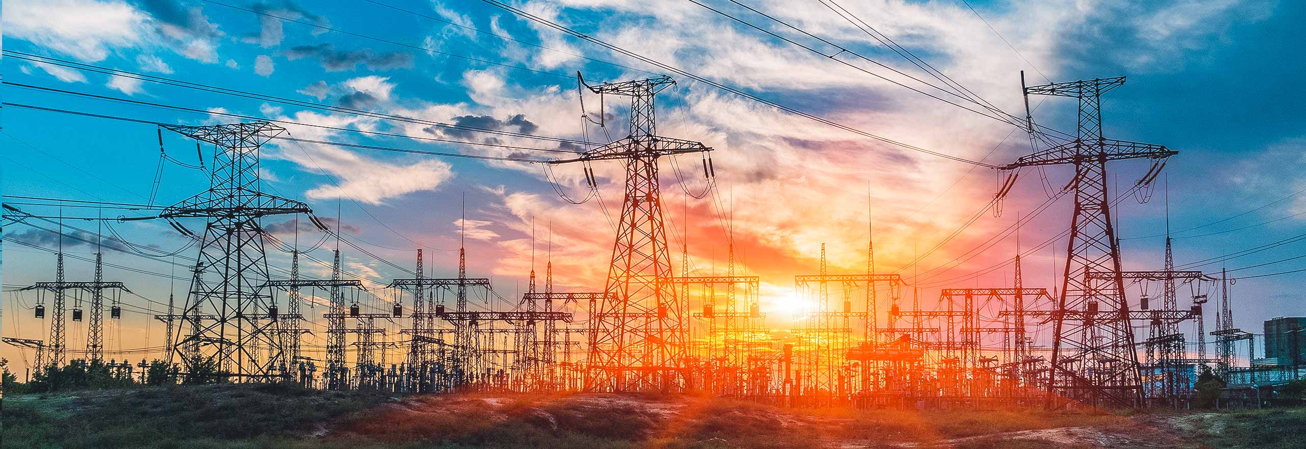 Distribution electric substation with power lines and transformers at sunset