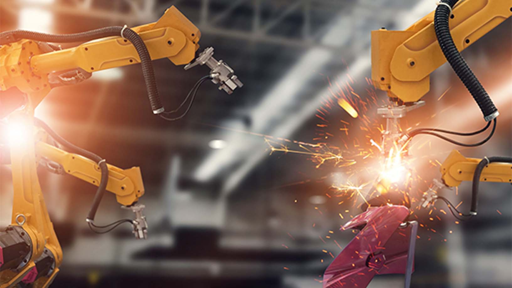 Industrial Engineer using a tablet to check and control automation robot arms in a smart factory environment